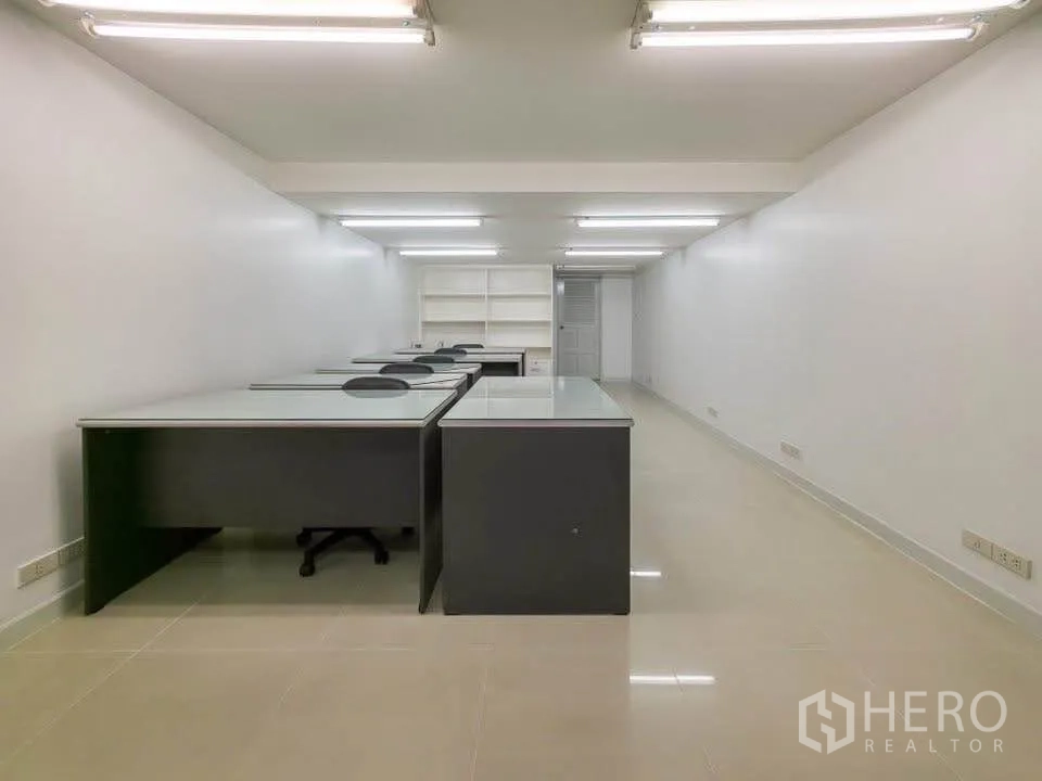 Office Space for rent in Khlong Toei, Bangkok - Deep office room fitted with rows of workstations under strip lighting.