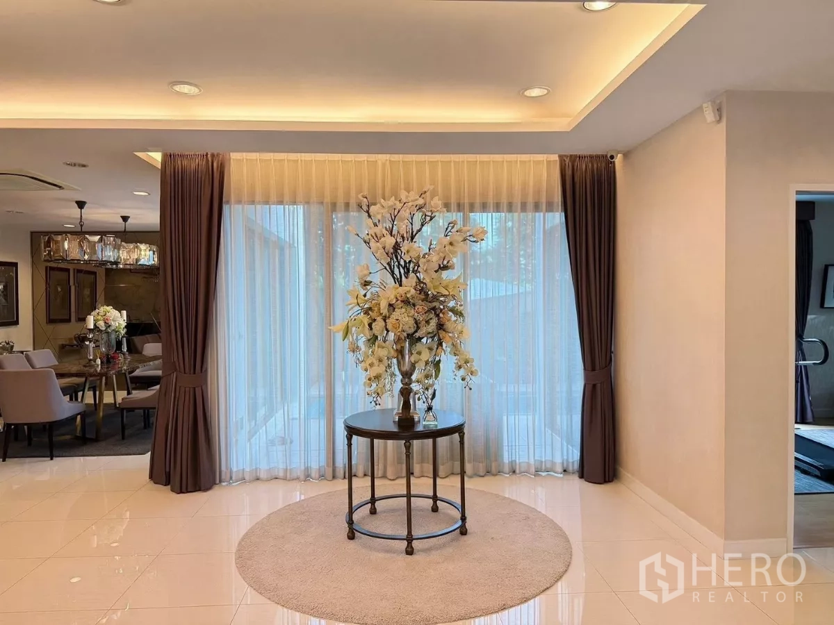 Detached House for rent or sale in Prawet, Bangkok - Spacious foyer with full-height curtains and centerpiece table under recessed lighting.
