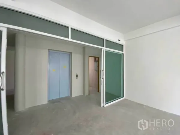Retail Space for rent in Khlong Toei, Bangkok - Elevator lobby with glass partitions and sliding doors in a commercial building.