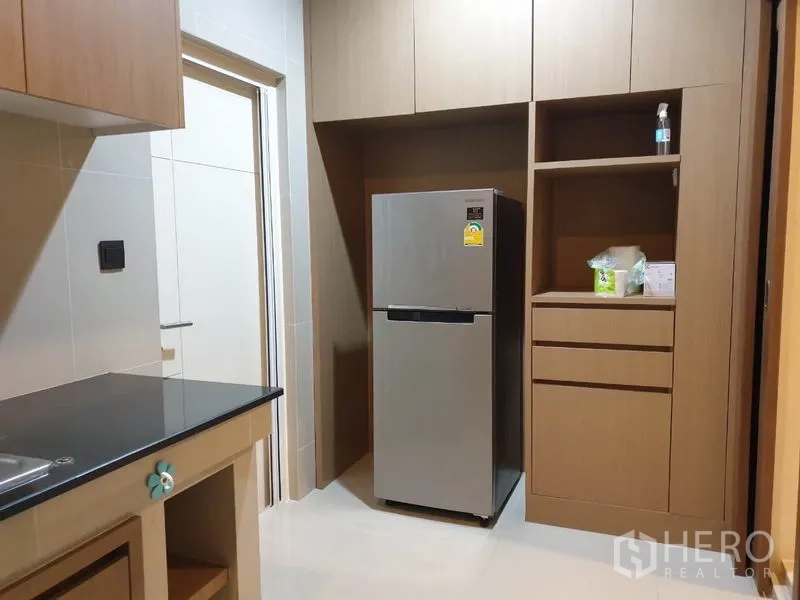 Detached House for rent in Bang Kapi, Bangkok - Kitchen storage wall with tall cabinets and a stainless steel refrigerator.