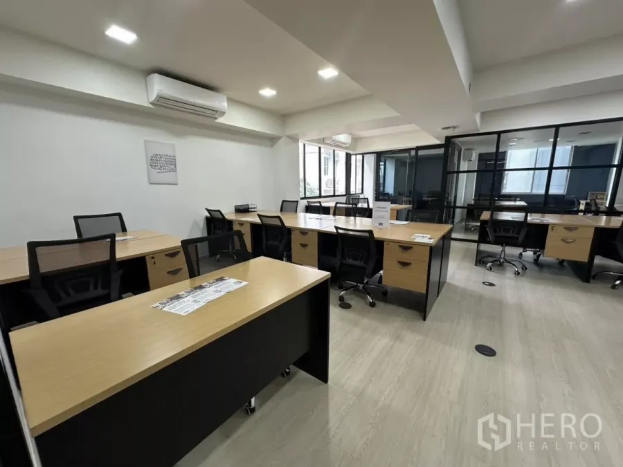 办公空间 出租在Watthana, Bangkok - 开放式办公区，木质工位、网背椅、LED照明，旁有玻璃隔断会议室。