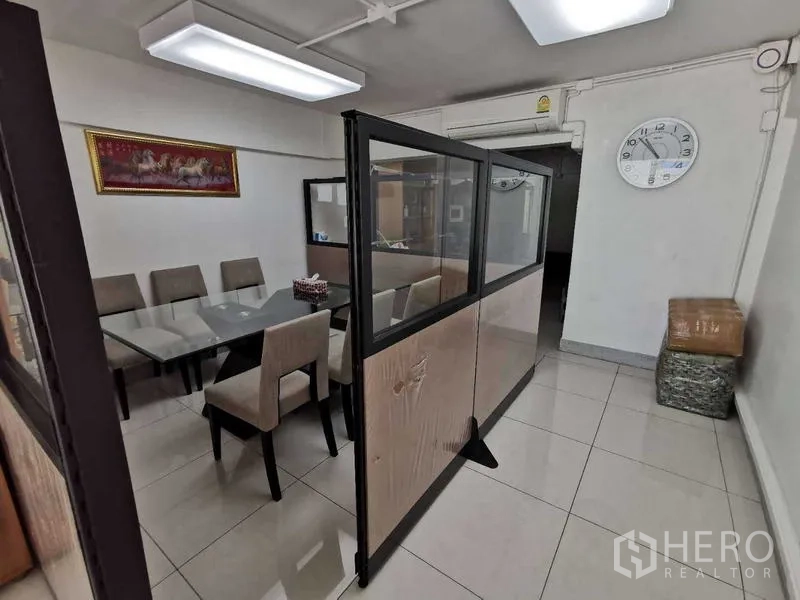 办公空间 出租在Huai Khwang, Bangkok - 以玻璃隔断分区的洽谈区，软包座椅与顶灯。