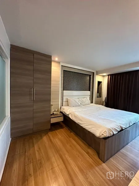 房间 出租在Khlong Toei, Bangkok - 卧室铺木地板，内置衣柜与大床。