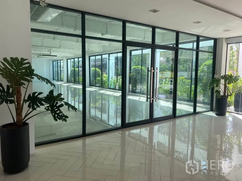Office Space for rent in Khlong Toei, Bangkok - Bright lobby with floor-to-ceiling glass partitions, double glass doors, potted plants and glossy tile floors.