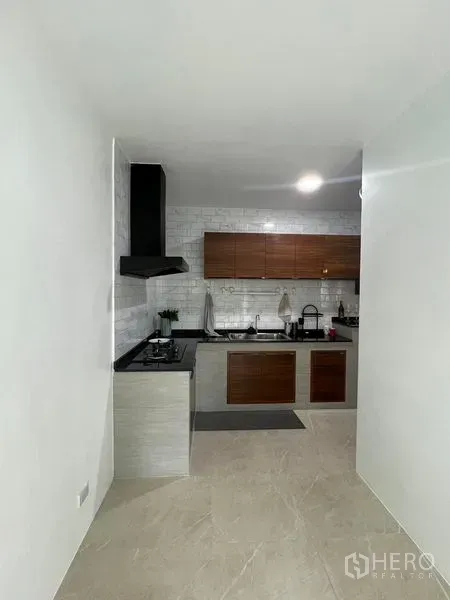 Townhouse for rent - Separate kitchen corridor with L-shaped counter and white subway-tile backsplash.