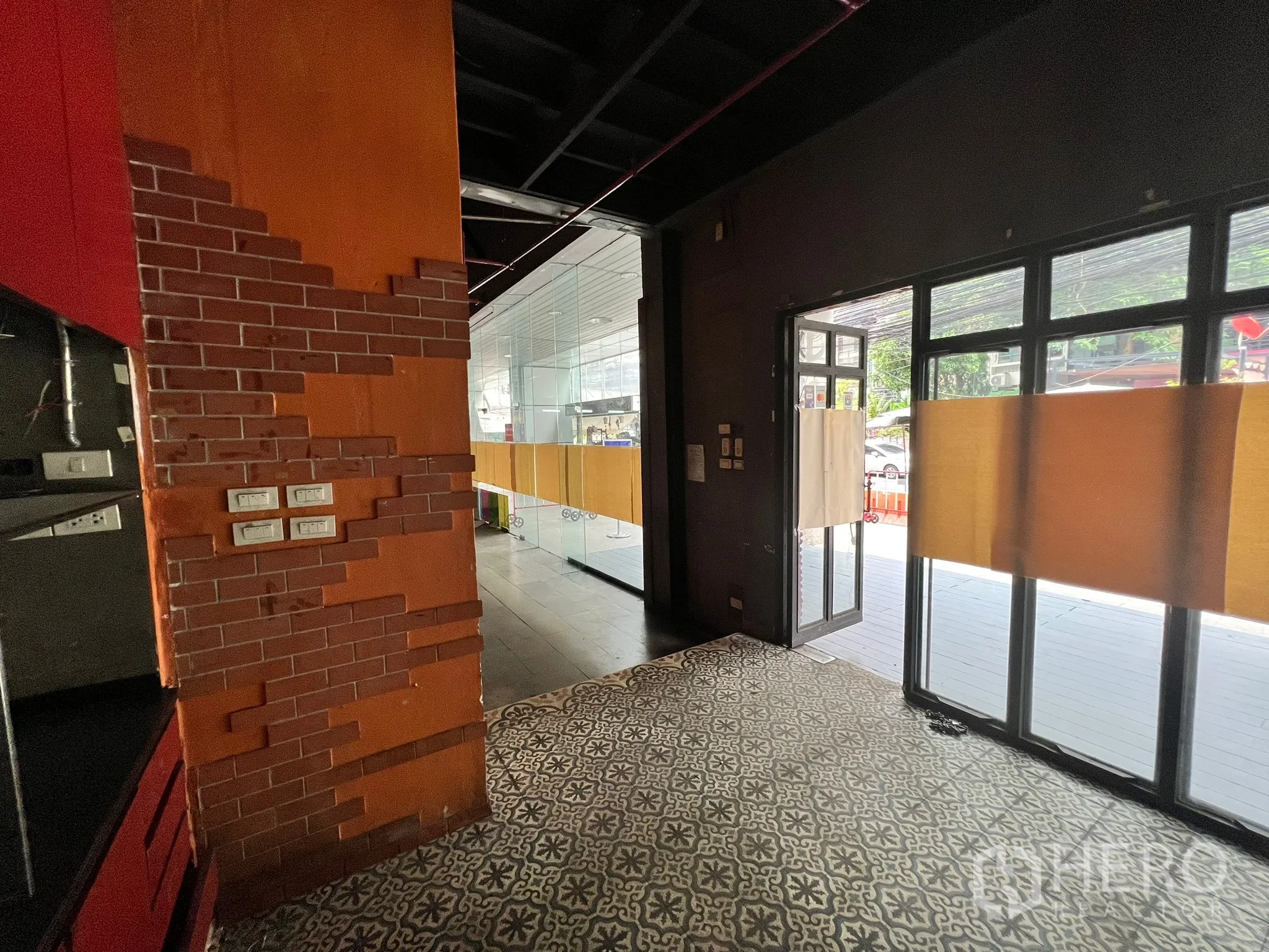 Retail Space for rent in Watthana, Bangkok - Entrance corner with orange brick accents, patterned tiles and double glass doors.