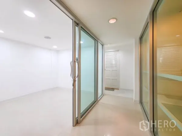 Office Space for rent in Khlong Toei, Bangkok - Hallway with glass partitions opening to a white meeting or office room.