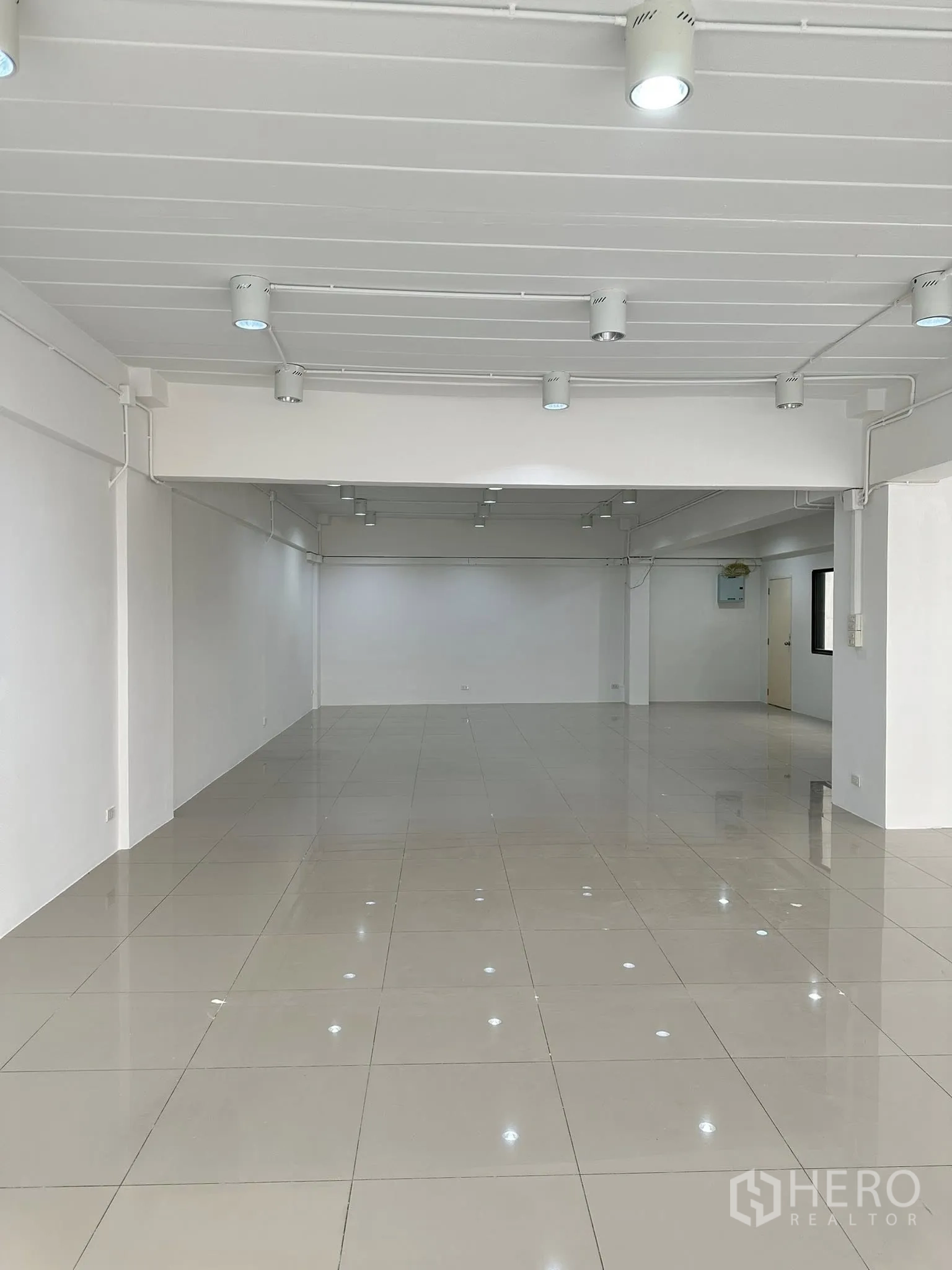 Office Space for rent in Watthana, Bangkok - Long view of large office area with multiple ceiling lights and polished tiles.