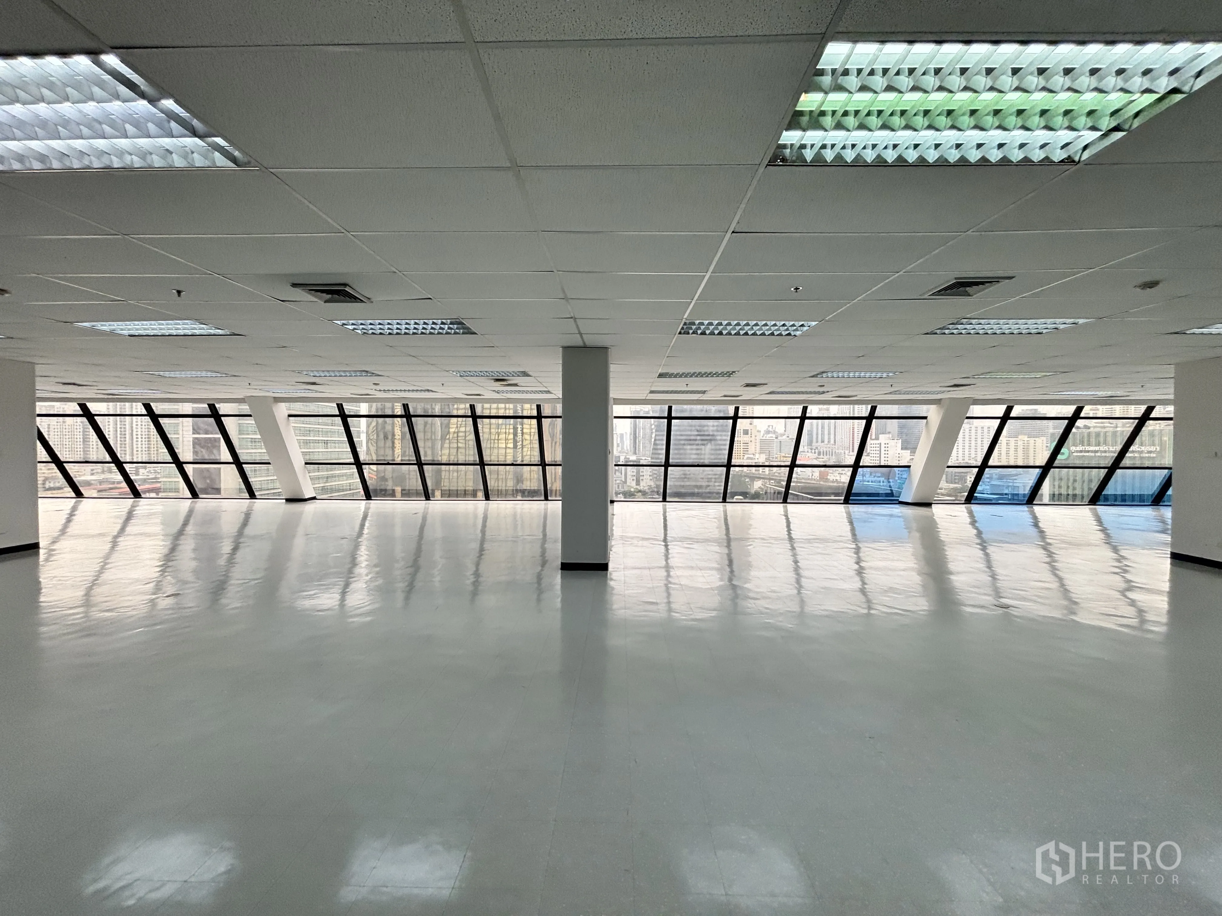 Office Space for rent in Ratchathewi, Bangkok - Wide office area facing wraparound glass windows offering skyline outlook and a grid ceiling with fluorescent lighting.