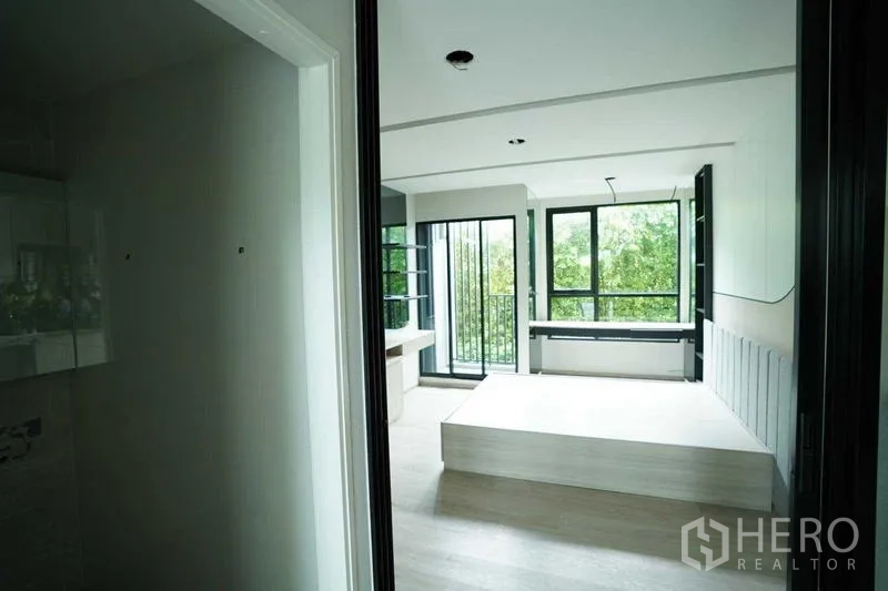 Standalone for rent in Bang Na, Bangkok - Entry view into a bright room with platform and sliding door to a balcony.