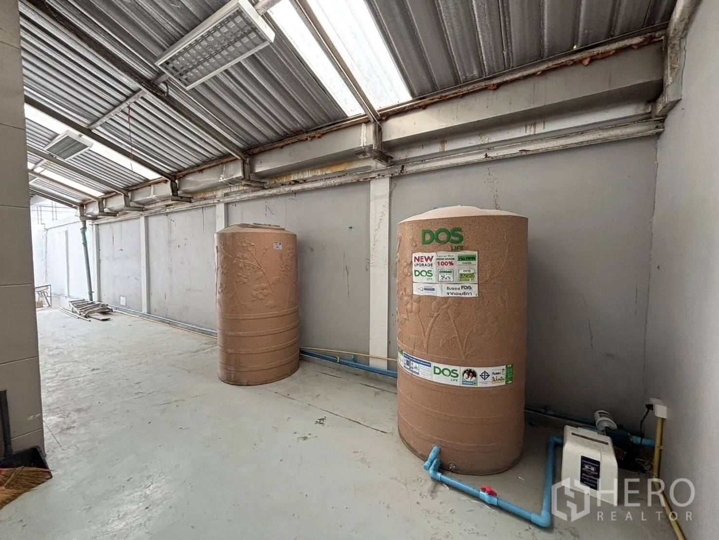 Warehouse for rent or sale in Wang Thonglang, Bangkok - Covered service area with twin water tanks and a pump.