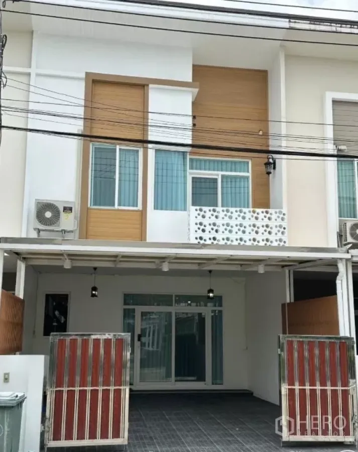 Townhouse for rent in Bang Phli, Samut Prakan - Modern two-storey townhouse facade with gated carport and balcony in Casa City Bangna.