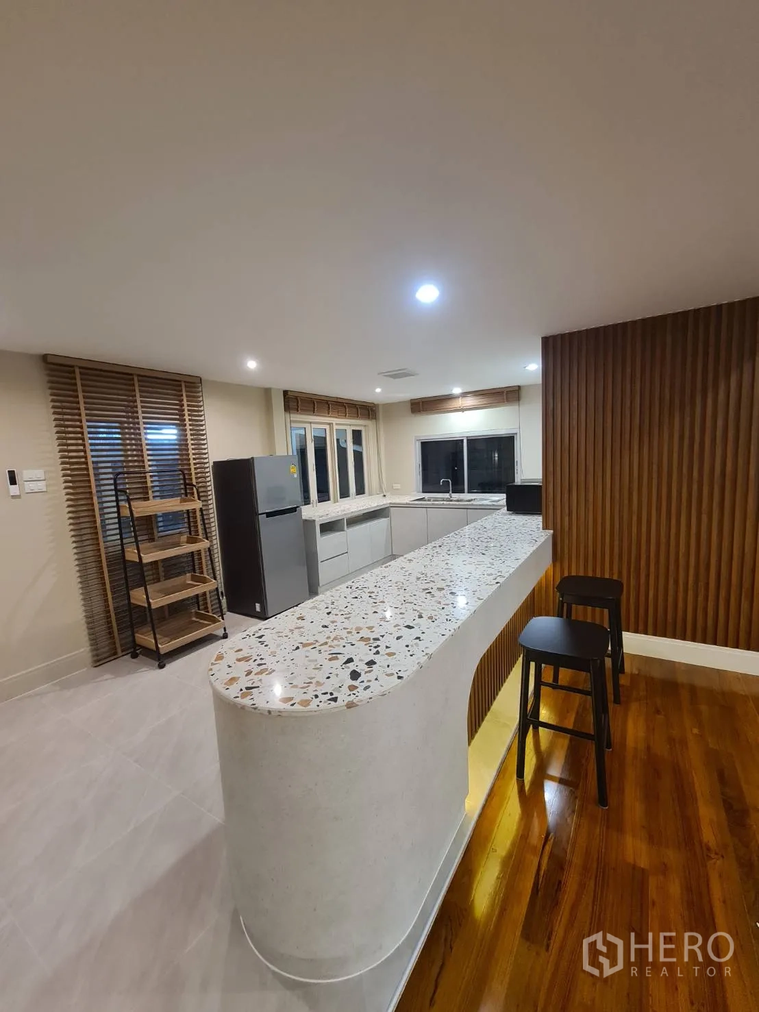 Detached House for rent in Khlong Toei, Bangkok - Contemporary kitchen featuring a terrazzo island, bar seating and ample cabinetry.