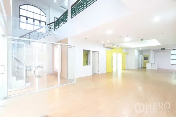 Office Space for rent in Bang Na, Bangkok - Double‑height lobby workspace featuring a staircase, glass doors and air‑conditioning, ideal for reception.