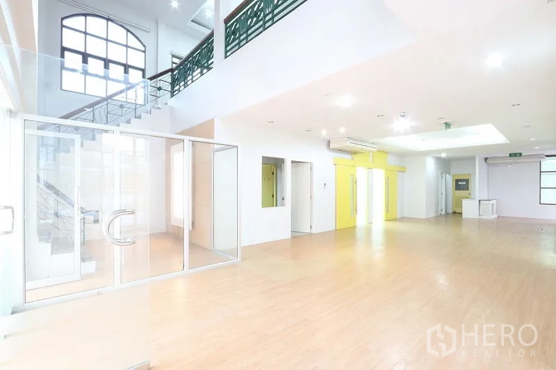 Office Space for rent in Bang Na, Bangkok - Double‑height lobby workspace featuring a staircase, glass doors and air‑conditioning, ideal for reception.
