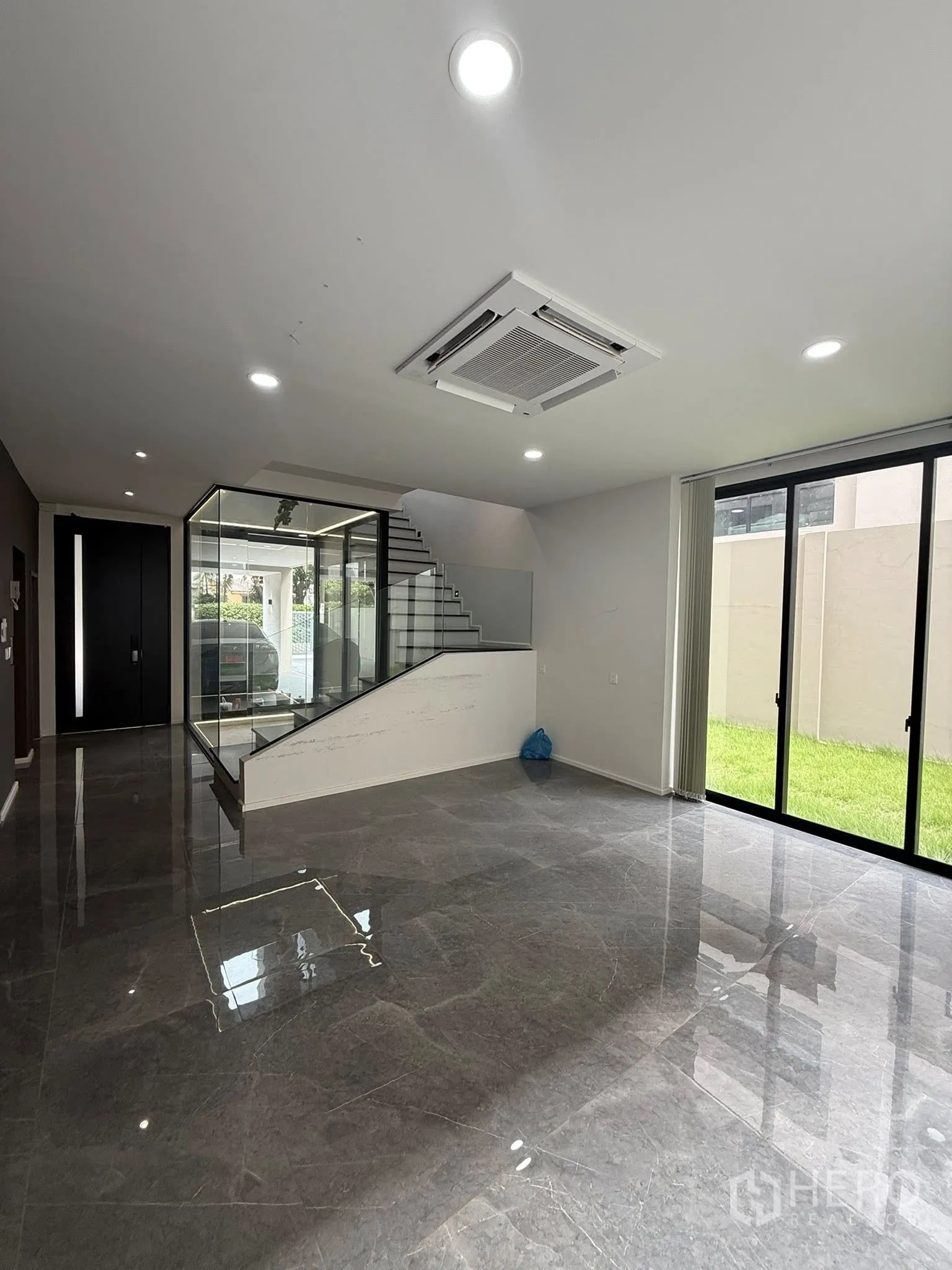 Home Office for rent or sale in Lat Phrao, Bangkok - Ground-floor multipurpose space with marble floors, cassette AC and sliding doors to a lawn.