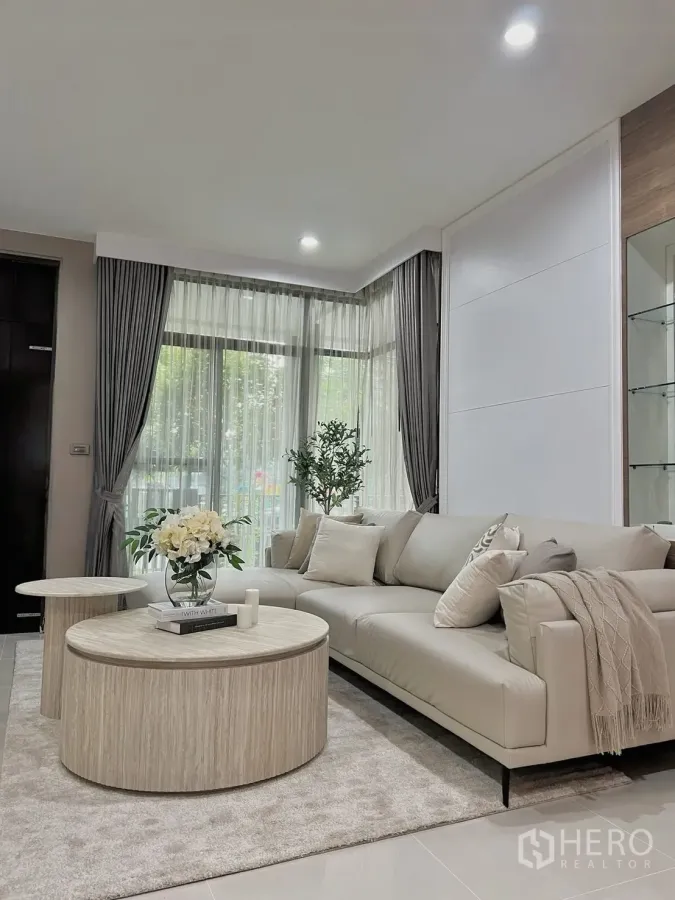 บ้านเดี่ยว for rent in Prawet, Bangkok - ห้องนั่งเล่นกว้าง โซฟารูปตัวแอล โต๊ะกลางทรงกลม และผ้าม่านสูงจดเพดาน