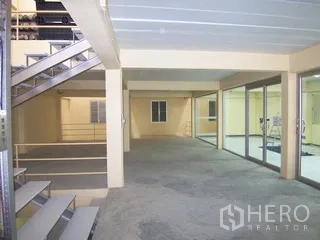 Factory for rent in Thung Khru, Bangkok - Landing with metal stairs and glass-partitioned rooms within the factory.
