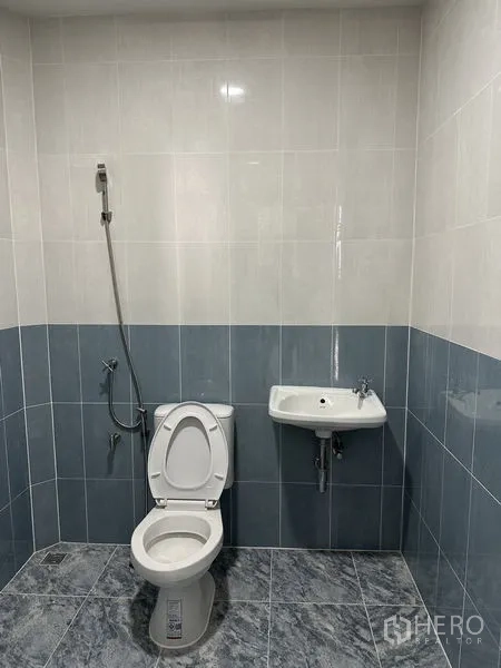 货栈 出租在Pak Kret, Nonthaburi - 干净的瓷砖卫生间，坐便器、洗手盆及喷枪。