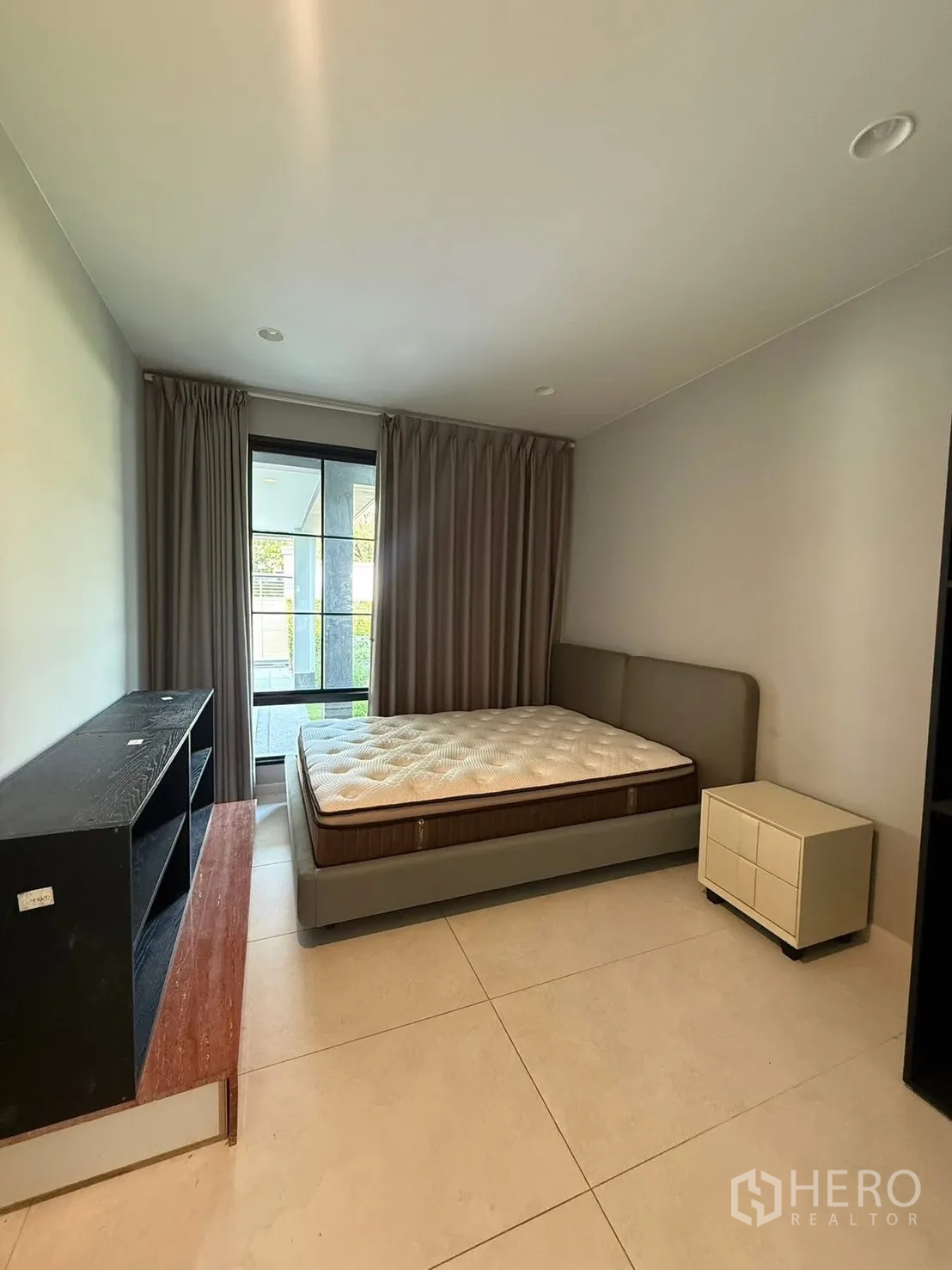 Detached House for rent in Bang Kapi, Bangkok - Guest bedroom with tiled floor, double bed, side table and sliding window.