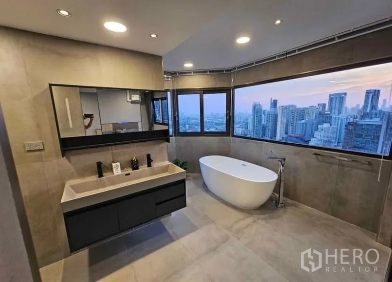 Condominium for rent or sale - Large ensuite bathroom with double vanity and tub, skyline backdrop.