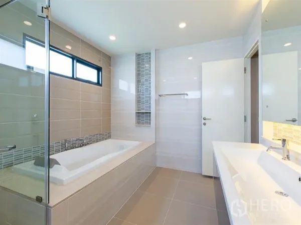 Detached House for rent or sale in Prawet, Bangkok - Contemporary bathroom with soaking tub, glass shower and double vanity.