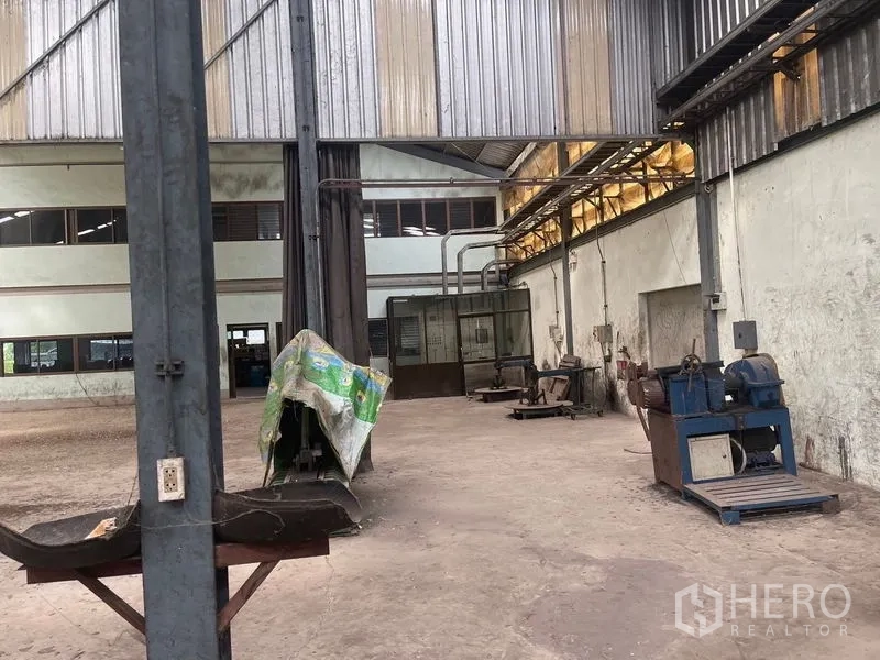 Warehouse for rent or sale in Bang Bon, Bangkok - Production zone with equipment, exhaust piping and a concrete floor.