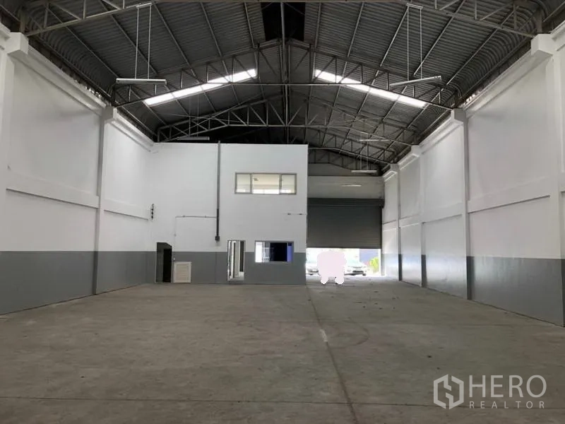 工厂 出租在Khlong Luang, Pathum Thani - 仓库内部视角，面向装卸卷闸门与夹层办公室。