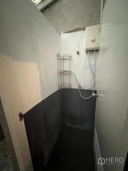 Shophouse for rent or sale in Watthana, Bangkok - Small shower cubicle with water heater and wall rack.