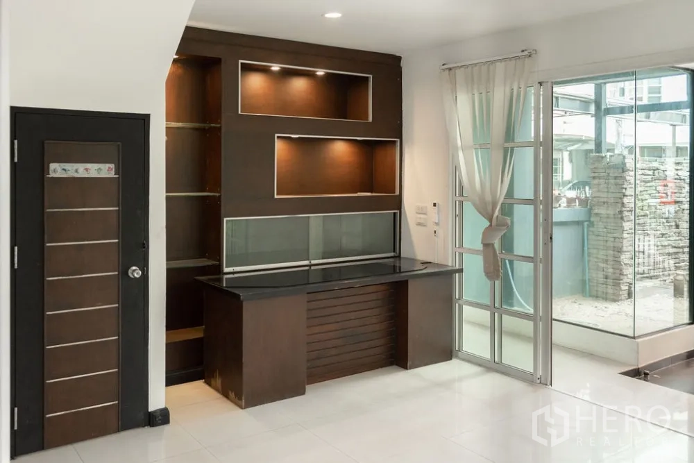Home Office for rent in Lat Phrao, Bangkok - Ground-floor reception area with built-in wood cabinet and sliding glass doors.