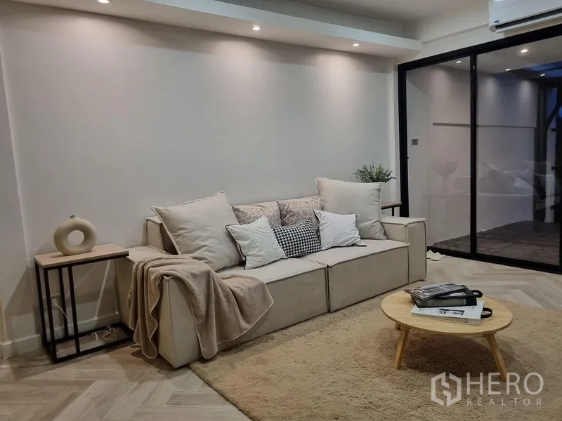 Townhouse for rent or sale - Cozy living area with sofa, recessed lighting and black-framed sliding glass doors.