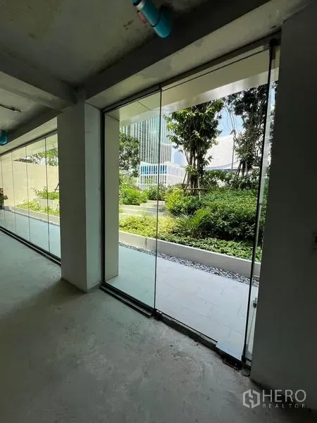 Retail Space for rent in Pathum Wan, Bangkok - Floor-to-ceiling glass storefront looking out to a lush courtyard garden.