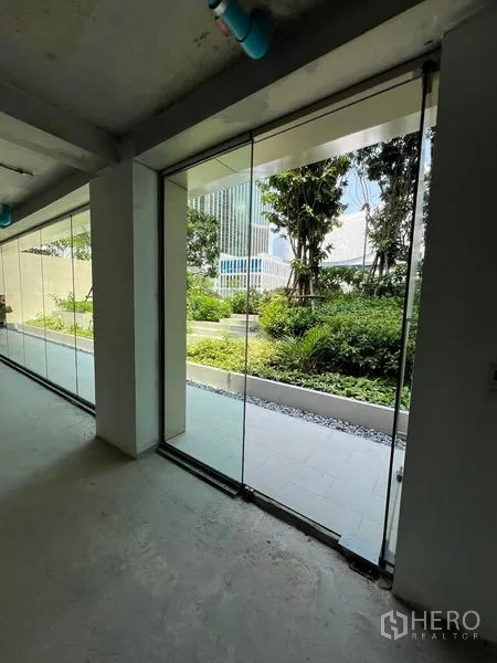 Retail Space for rent in Pathum Wan, Bangkok - Floor-to-ceiling glass storefront looking out to a lush courtyard garden.