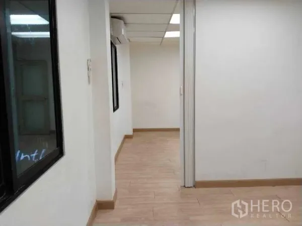 Office Space for rent in Bang Na, Bangkok - Hallway leading to private offices with interior windows and air-conditioning.