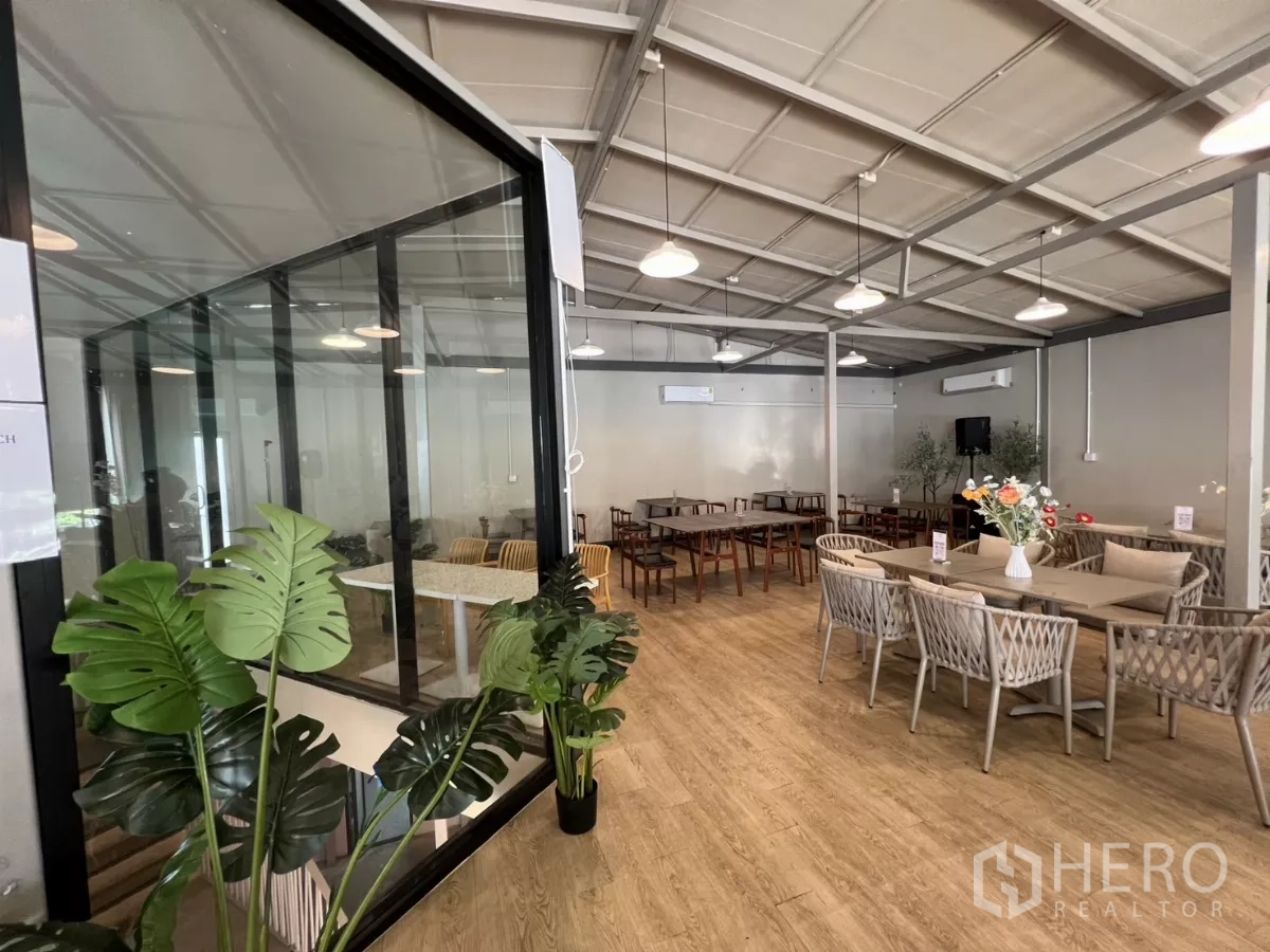 Retail Space for rent in Khlong Toei, Bangkok - Spacious cafe-like room with glass meeting room, pendant lights, plants and woven seating.