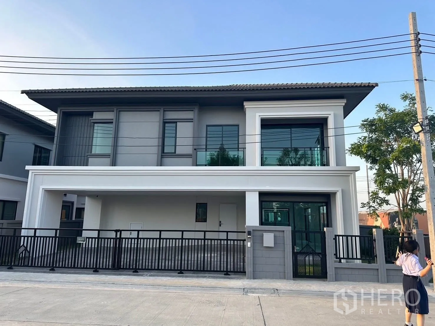 Detached House for rent in Bang Phli, Samut Prakan - Contemporary two‑storey detached house exterior with glass balcony, gated frontage and covered parking.