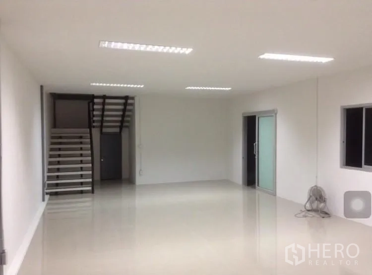 Warehouse for rent in Bang Kapi, Bangkok - Bright office room with tiled floors, fluorescent lighting, windows and sliding glass doors.