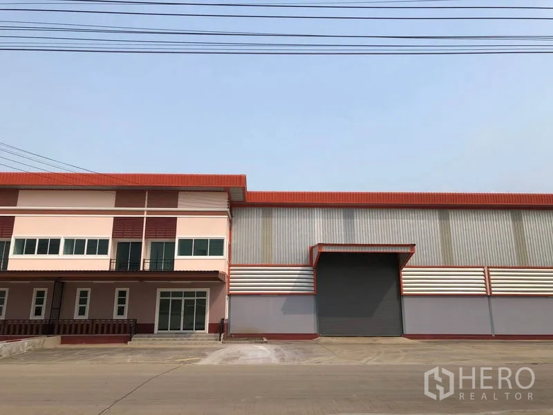 Factory for rent in Bang Len, Nakhon Pathom - Front elevation of factory with attached office building and a large roller shutter.