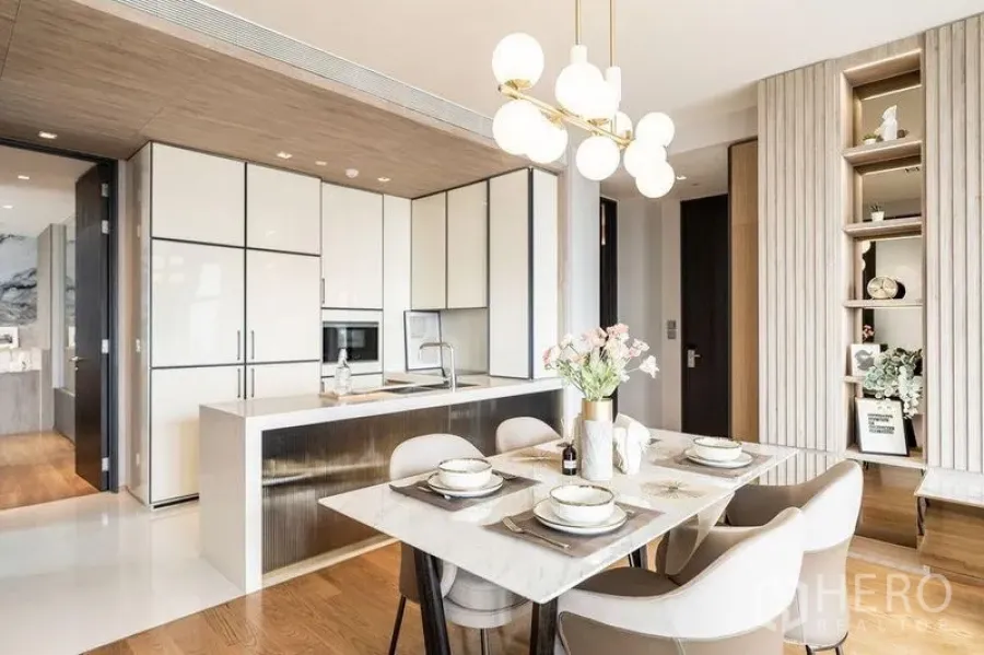 Condominium for rent in Khlong Toei, Bangkok - Elegant dining and kitchen zone with pendant lighting, island counter, and warm wood flooring.