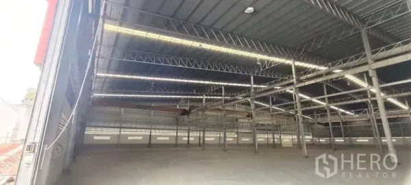 Warehouse for rent in Nikhom Phatthana, Rayong - Spacious warehouse interior with high steel truss roof, skylight strips and open concrete floor.