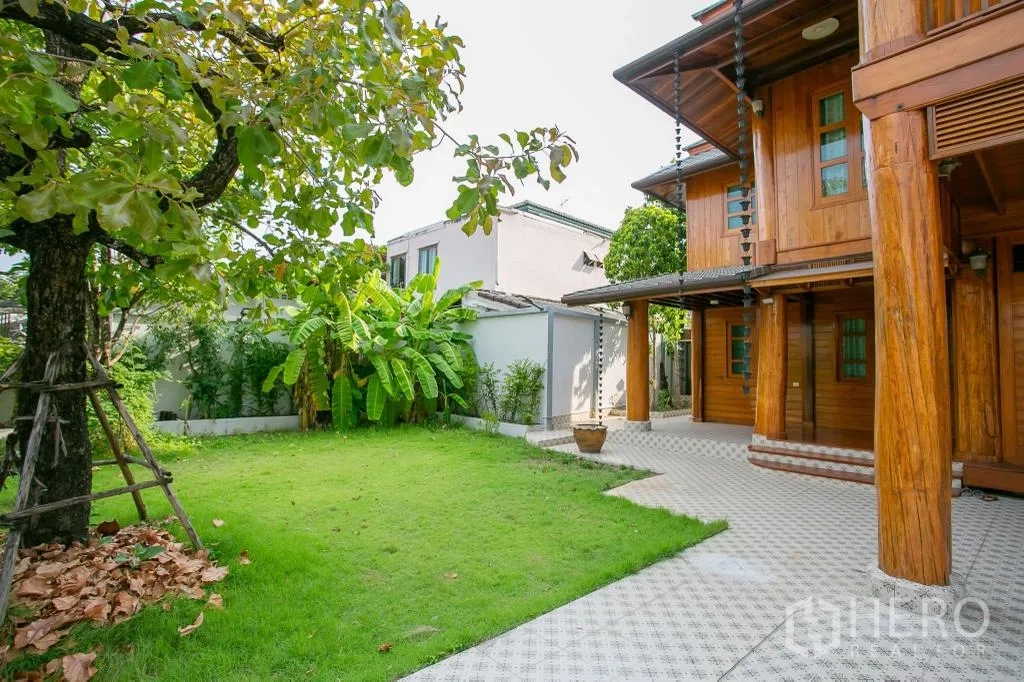 Detached House for rent or sale in Huai Khwang, Bangkok - Shaded backyard lawn with banana trees next to the timber house.