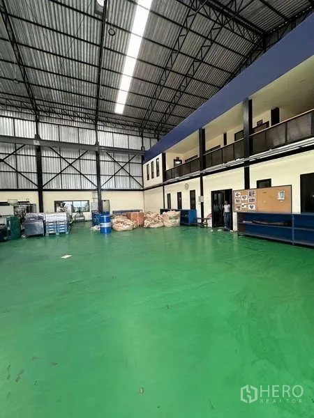Factory for sale in Si Racha, Chon Buri - Open factory floor with mezzanine office wing, storage area and shelving.