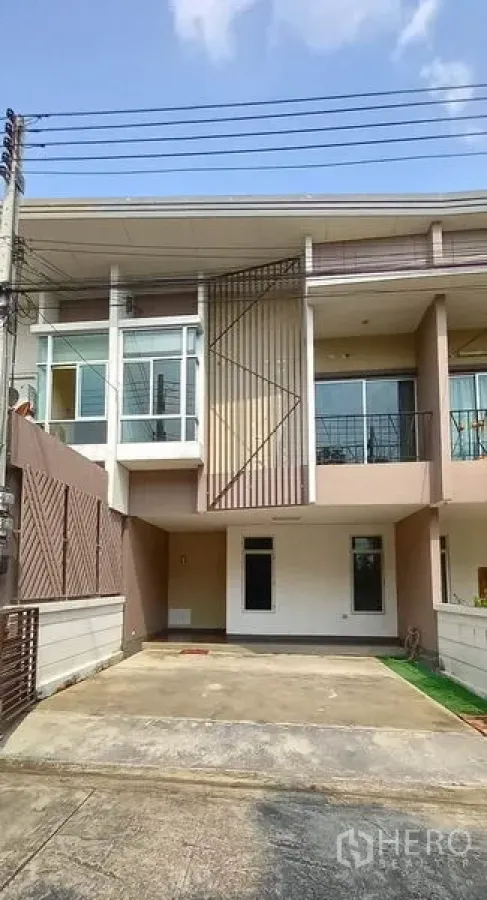 联排别墅 出售在Mueang Pathum Thani, Pathum Thani - 现代两层联排外立面，带阳台与有顶停车位。