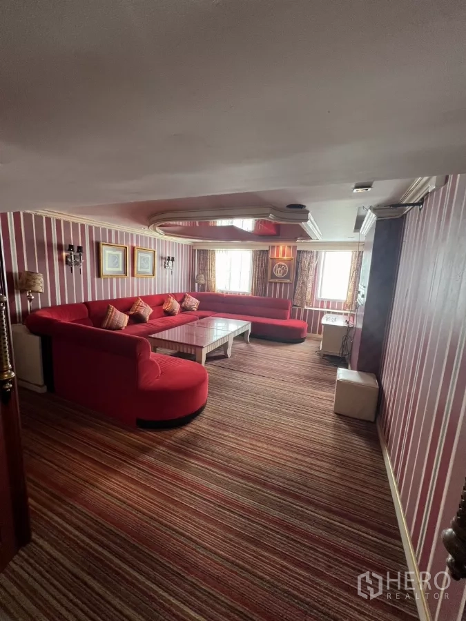 Retail Space for rent in Watthana, Bangkok - Striped-wall lounge featuring a large red sectional sofa with good natural light.