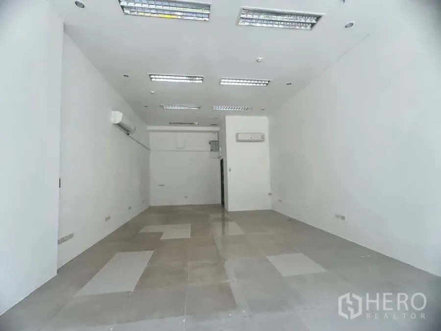 Retail Space for rent in Khlong Toei, Bangkok - Bright white-box retail unit with tiled flooring, recessed fluorescent lighting, and wall-mounted air conditioners.