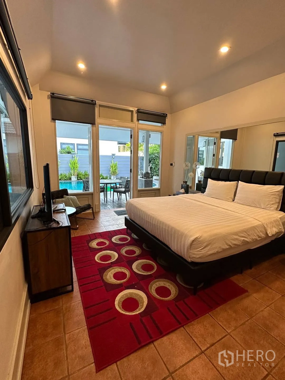 Detached House for rent in Watthana, Bangkok - Bedroom with king bed and red rug opening to the pool terrace.
