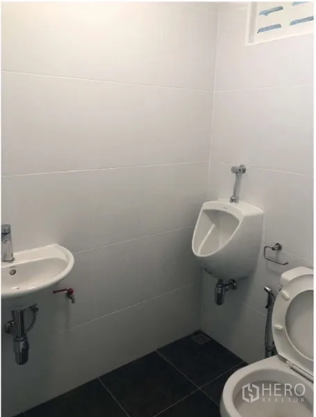 Shophouse for rent in Watthana, Bangkok - Clean tiled restroom with sink, urinal and toilet inside the shophouse.
