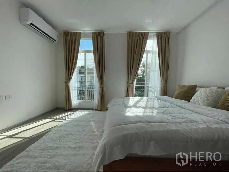 Detached House for rent in Prawet, Bangkok - Spacious master bedroom with large windows, balcony doors and air conditioning.