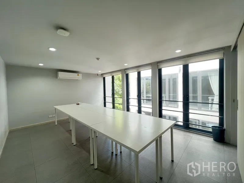 Home Office for rent or sale in Phra Khanong, Bangkok - Meeting room with folding tables and balcony doors overlooking atrium.