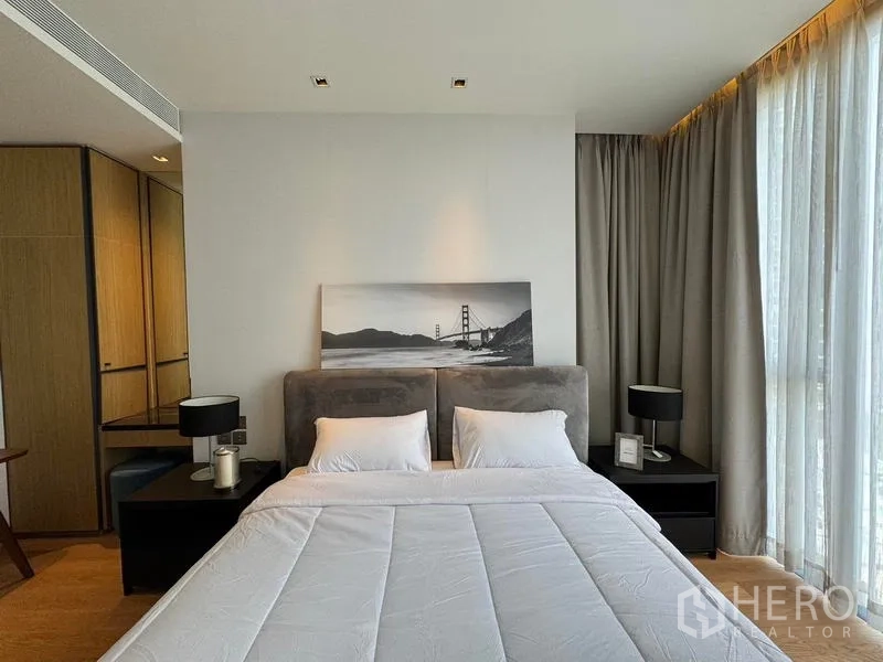Condominium for rent - Close view of master bed with padded headboard and artwork beside curtain wall.